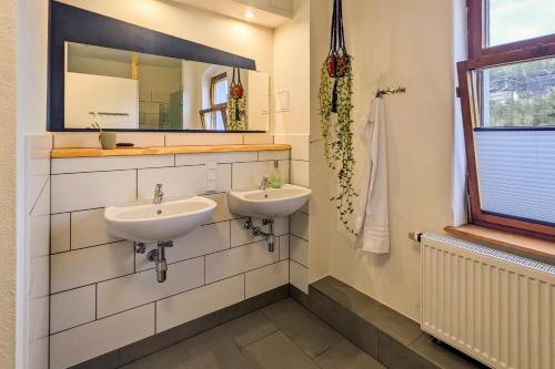 a bathroom with two sinks and a mirror at Hinterland Hostel in Rathen
