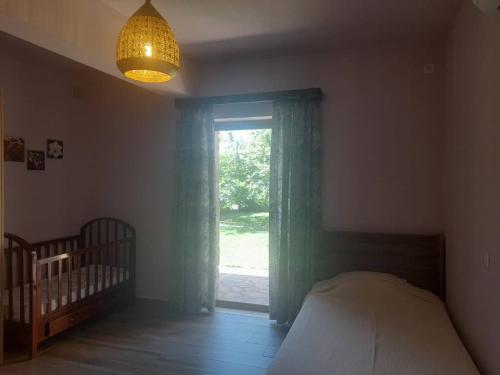 a bedroom with a bed and a window and a crib at Platanus Gardenhouse in Anavissos