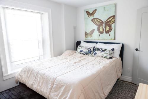 a bedroom with a bed with butterflies on the wall at Modern Apt Near Downtown Ideal for long stays - U3 - The Deco in Burlington