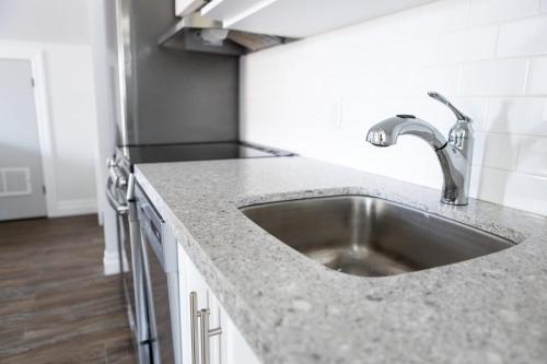 a kitchen counter with a sink in a kitchen at Modern Apt Near Downtown Ideal for long stays - U3 - The Deco in Burlington