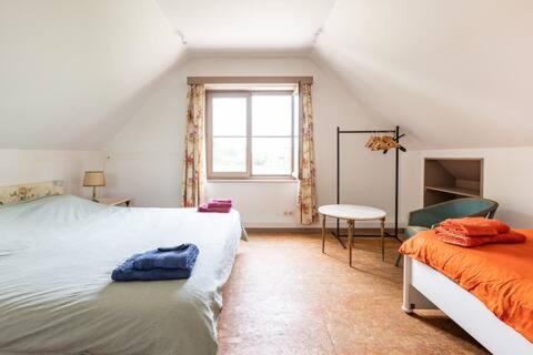 1 dormitorio con 2 camas y ventana en Vakantiehuis Wandelen en fietsen in de Kalkense Meersen dichtbij Gent, en Laarne