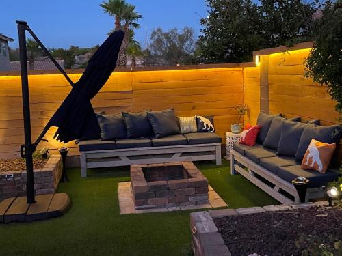 a patio with a couch and a hammock on the grass at Gorgeous Henderson Home with Pool! in Las Vegas