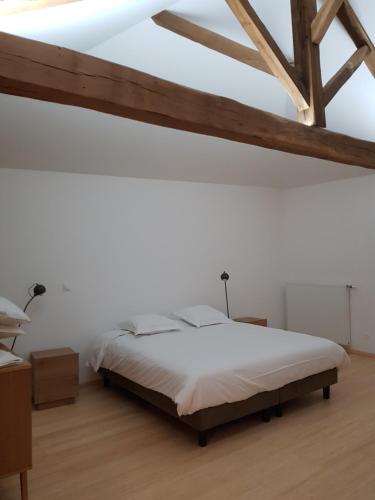 1 dormitorio blanco con 1 cama y techo de madera en La Mollerie, en Saint-Bonnet-de-Cray