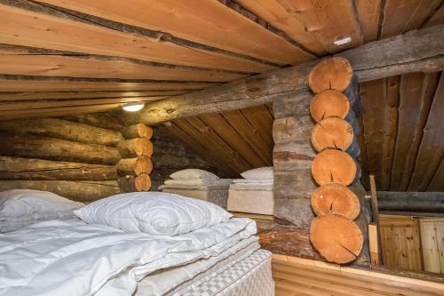 a bedroom with a bed in a log cabin at Pihlakieppi 1 in Ruka