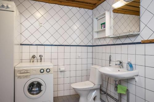 a bathroom with a toilet sink and a washing machine at Pihlakieppi 1 in Ruka