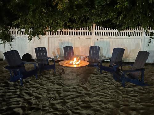 a fire pit with chairs and a table in the sand at Sunbird Cape Cod Resort in West Yarmouth