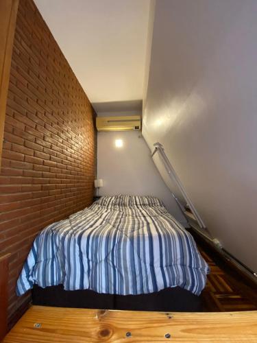 a bed in a room with a brick wall at Roosevelt in Buenos Aires