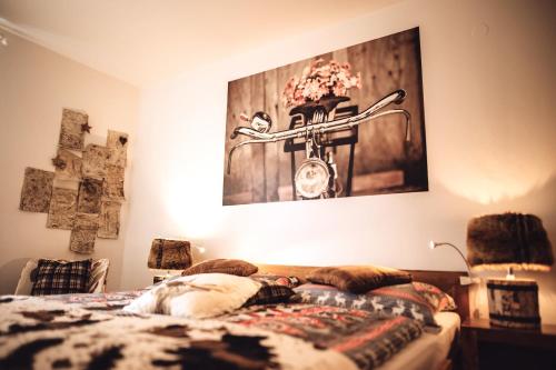 a bedroom with a bed with a picture on the wall at Das Hotel Stern, B&B KG - digital & contactless check-in in Sankt Gilgen