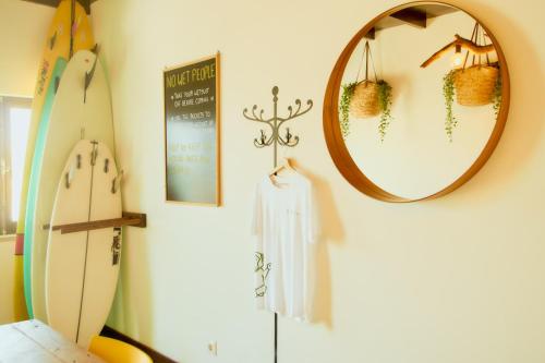 una camera con specchio e tavola da surf di Balili Surf House a Baleal