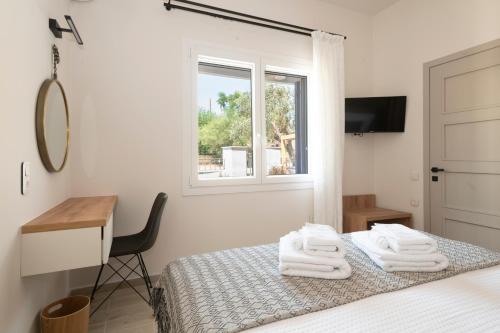 une chambre avec un lit, un bureau et une fenêtre dans l'établissement Camara Luxury Apartments (Deluxe Apartment), à Pylos