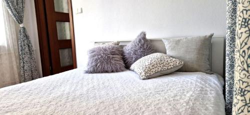 łóżko z fioletowo-białymi poduszkami w obiekcie Apartamenty dobowe w centrum Warszawy w Warszawie
