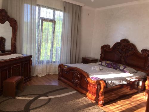 a bedroom with a large wooden bed and a window at Guest House Dimitri in Chakvi