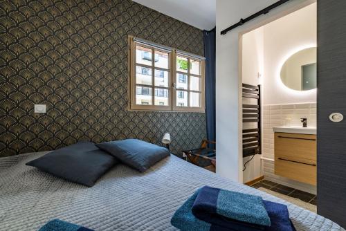 une chambre avec un lit et une salle de bain avec un lavabo dans l'établissement Dijon : plein coeur de ville, à 2 pas du Tram, à Dijon