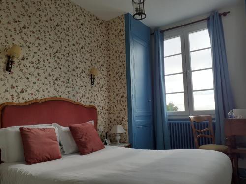 a bedroom with a bed with a red headboard and a window at Hotel de Charme La Bonne Adresse - Logis hotels in Le Havre