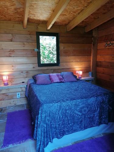une chambre avec un lit dans une cabane en rondins dans l'établissement Mas Ribou, à Barbentane