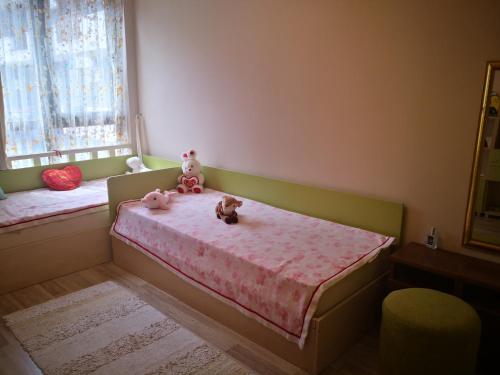 two stuffed animals sitting on a bed in a bedroom at Apart Complex Amphora Palace in Golden Sands