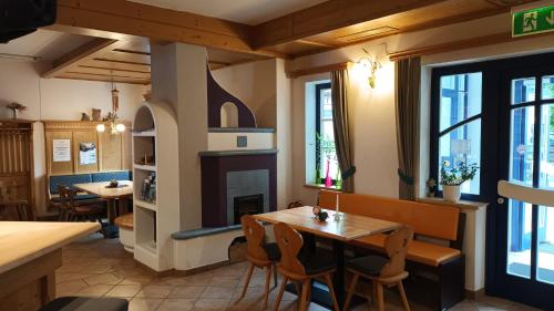 a restaurant with tables and chairs and a fireplace at Gasthof zum Postwirt in Predlitz