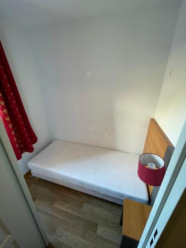 a small room with a bed and a red curtain at Appartement Les Chalets de Belledonne in Saint-Colomban-des-Villards