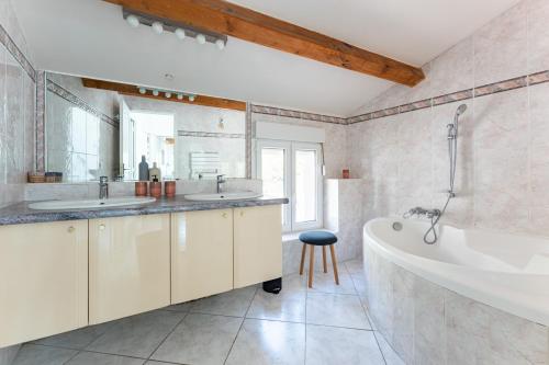 a bathroom with two sinks and a bath tub at A LA CALANQUE - Jolie Maison en bord de mer in Marseille