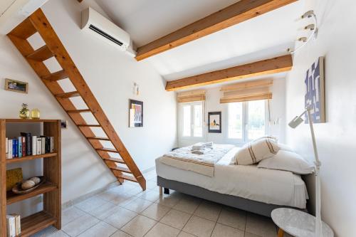 a bedroom with a bed and a staircase at A LA CALANQUE - Jolie Maison en bord de mer in Marseille
