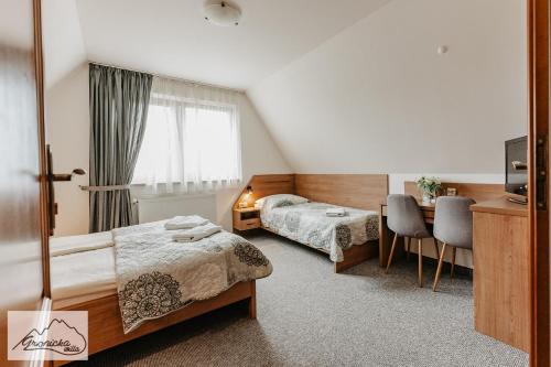 a hotel room with two beds and a table at Willa Gronicka in Białka Tatrzanska