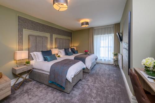 a hotel room with two beds and a television at Maple Valley Guesthouse in Limerick