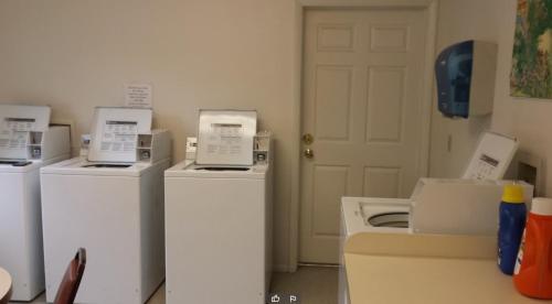 a room with three washing machines and a white door at GetAways at Timbers at Island Park Village in Island Park
