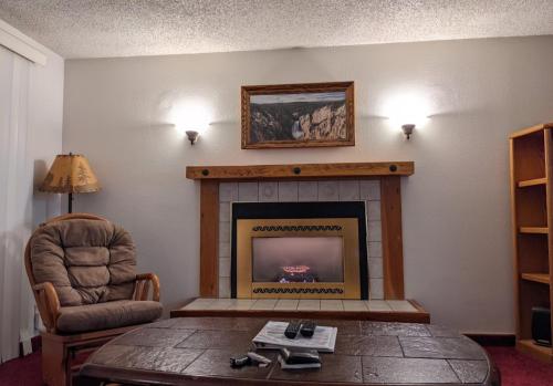 a living room with a fireplace and a chair at GetAways at Timbers at Island Park Village in Island Park