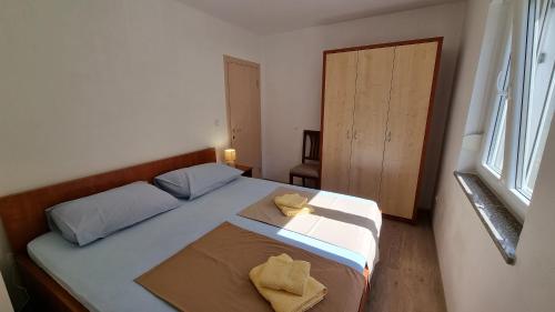 a bedroom with a bed with two yellow pillows on it at Apartments Bellator in Šilo