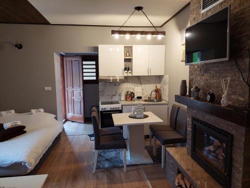 Cette chambre comprend un lit, une table et une cheminée. dans l'établissement Vila MINA, à Bajina Bašta