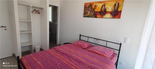 a bedroom with a bed with a pink comforter at chambre au pied de la forêt in Onesse-et-Laharie