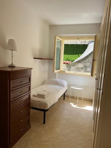 een kleine slaapkamer met een bed en een raam bij Lago e Giardino apartment in Bellagio