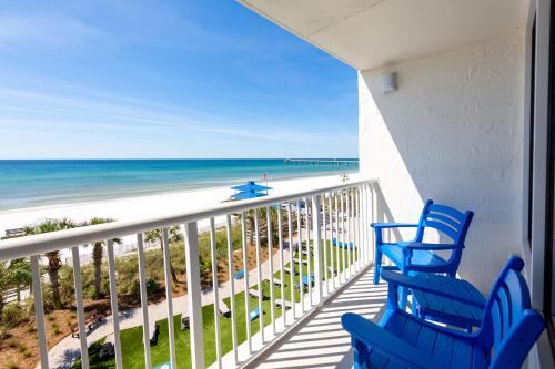 a balcony with blue chairs and the beach at The Island Resort at Fort Walton Beach in Fort Walton Beach