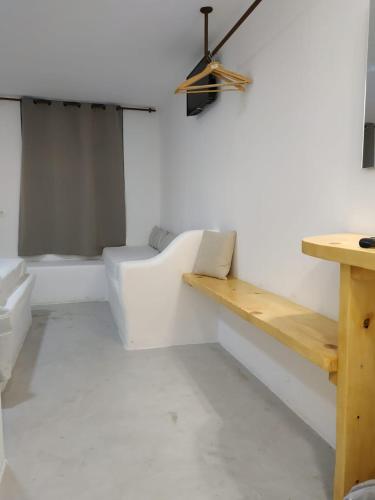 a white room with a bench and a table at Vista Mare in Naousa