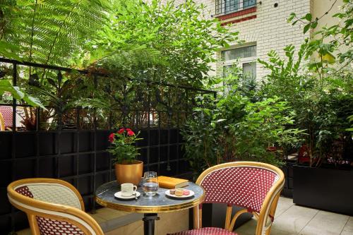 a table and chairs on a patio with plants at Hotel Villa Romantic & Spa in Paris