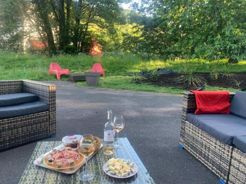 une table avec une assiette de nourriture et des verres de vin dans l'établissement Gîte de la Couze pavin, à Besse-et-Saint-Anastaise