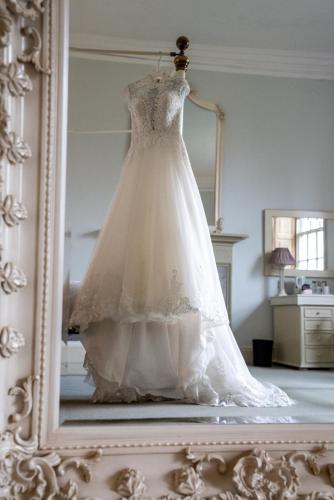 a wedding dress hanging in front of a mirror at The Old Deanery - Restaurant With Rooms in Ripon