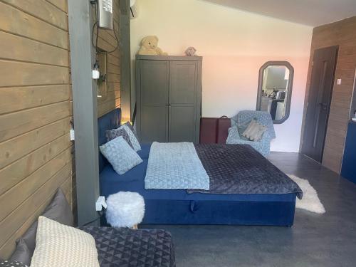a bedroom with a blue bed and a mirror at MonPe apartmánik s atmosférou in Komárno