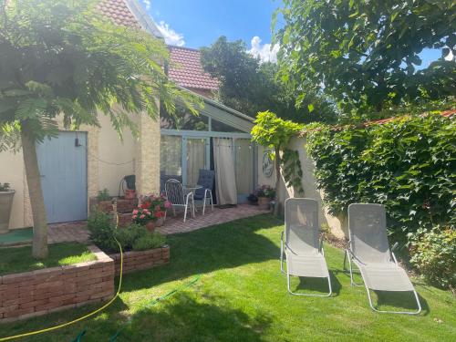 two lawn chairs in the yard of a house at MonPe apartmánik s atmosférou in Komárno