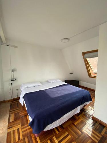 a bedroom with a large bed with a blue blanket at Roosevelt in Buenos Aires