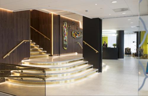 a staircase in a lobby with shiny metal steps at Thon Hotel Rosenkrantz Oslo in Oslo