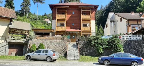 two cars parked in front of a building at Villa Hope (Vila Speranta) in Băile Tuşnad