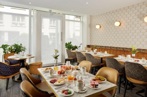 a restaurant with tables and chairs with food on them at Hotel Villa Romantic & Spa in Paris