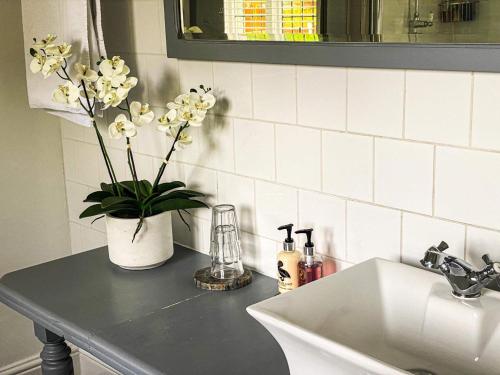 a kitchen counter with a sink and a vase with flowers at Castle Hotel in Eynsford