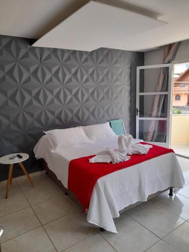 a bedroom with a bed with a red blanket at LUZ DO LUAR in Pedra Azul