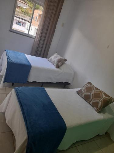 two beds in a room with a window at LUZ DO LUAR in Pedra Azul