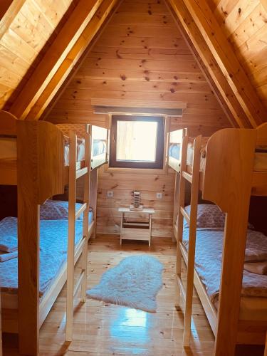 a room with three bunk beds in a cabin at Guest House LENA in Žabljak