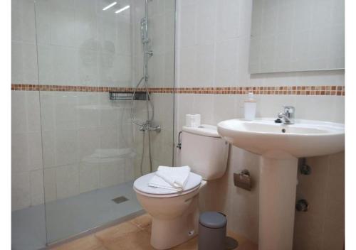 y baño con aseo, lavabo y ducha. en Anahi Homes Corralejo -Villa Codeso 7, en La Oliva