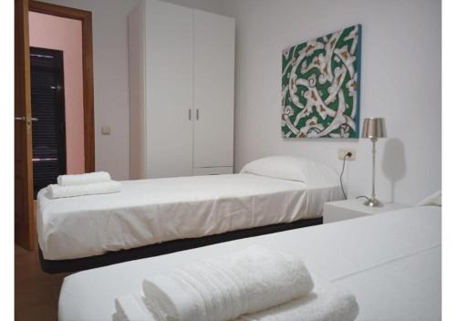 2 camas en una habitación blanca con toallas en una mesa en Anahi Homes Corralejo -Villa Codeso 7, en La Oliva