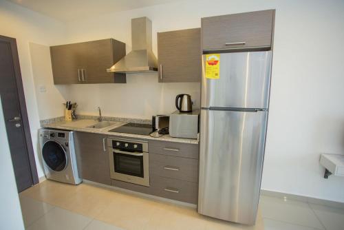 a kitchen with a stainless steel refrigerator and a dishwasher at The Gallery Luxury Apartments in Accra